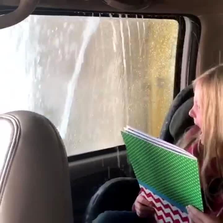 Video thumbnail showing: A young girl in a car gets scared and screams as the car goes through a car wash and water comes in through an opening in the window.