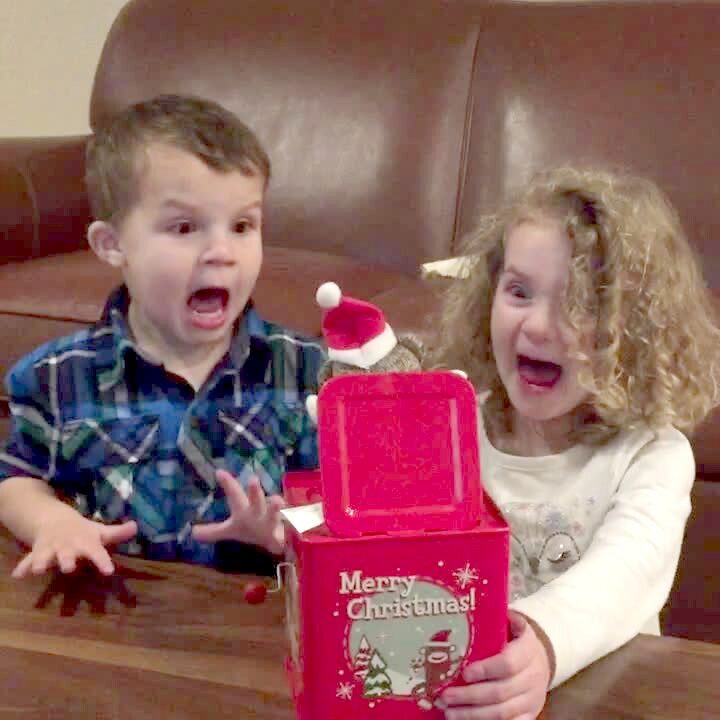 Video thumbnail showing: A young girl and boy crank a jack-in-the-box in the living room and scream when it pops open.