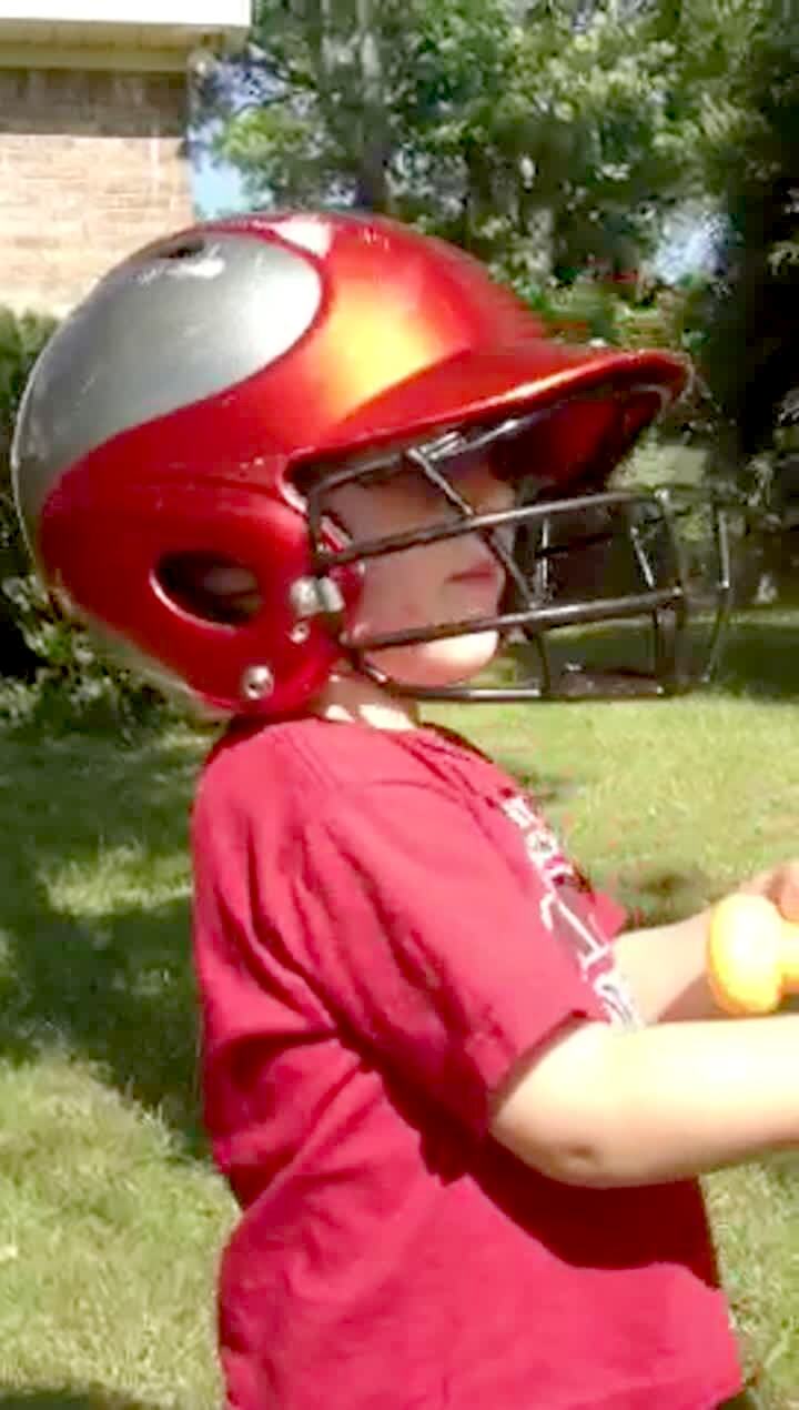 Video thumbnail showing: A little boy plays with a tee ball outdoors and gets confused when the man behind the camera says 'batter up.' The boy goes to his sister and hits her with the bat. Baseball