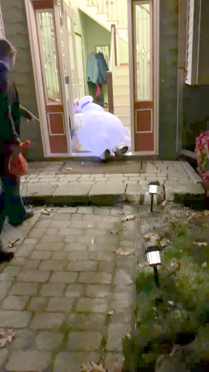 Video thumbnail showing: A young boy shows off his Stay Puft Marshmallow Man costume by the front door and leans back on the door, falling into the house.